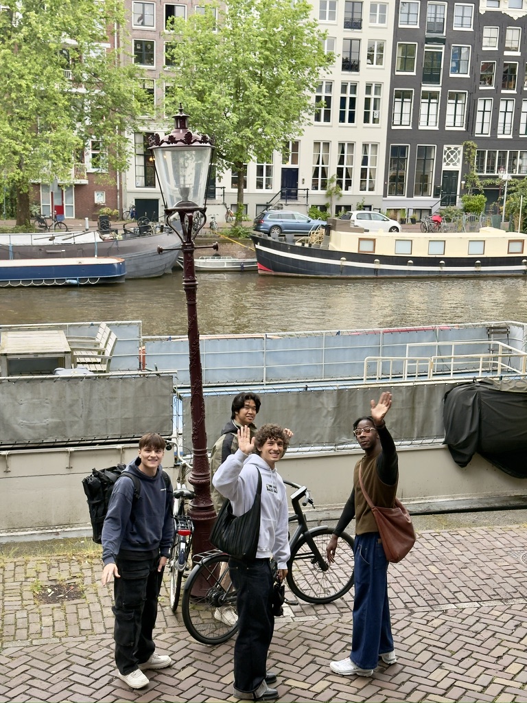 friends looking up and waving from beside the canal