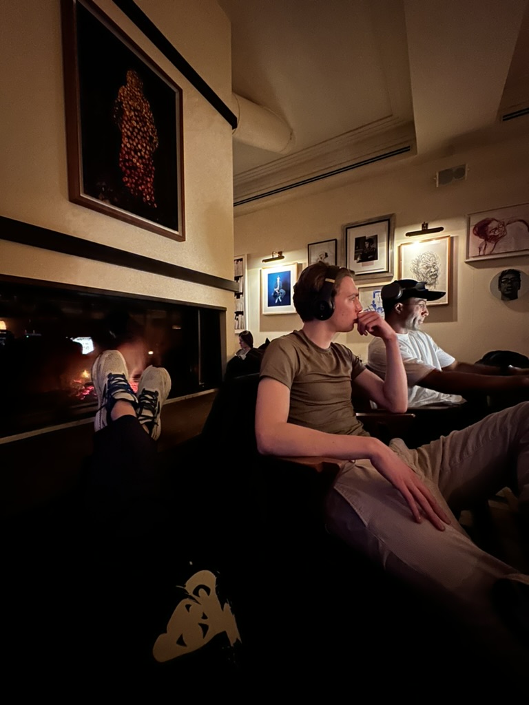 wearing headphones beside a fireplace