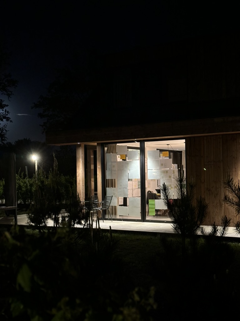 illuminated cabin windows covered with paper sketches at night